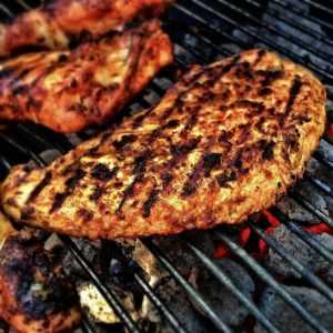 Home BBQ zonder zorgen: vrienden genieten van buiten koken met gegrilde gerechten en dranken bij elkaar