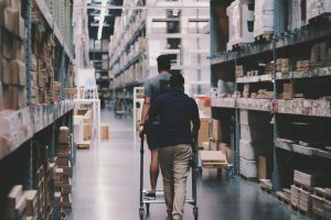 Home Werknemer gebruikt rolcontainer voor veilige material handling en ergonomie op werkplek