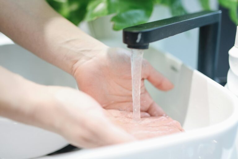 Afvoerbuis met waterdruppels, symbool voor verstoppingen in Zuid-Holland en het belang van preventief onderhoud